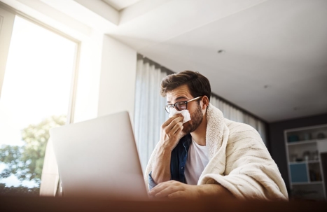 Man sneezing into a tissue